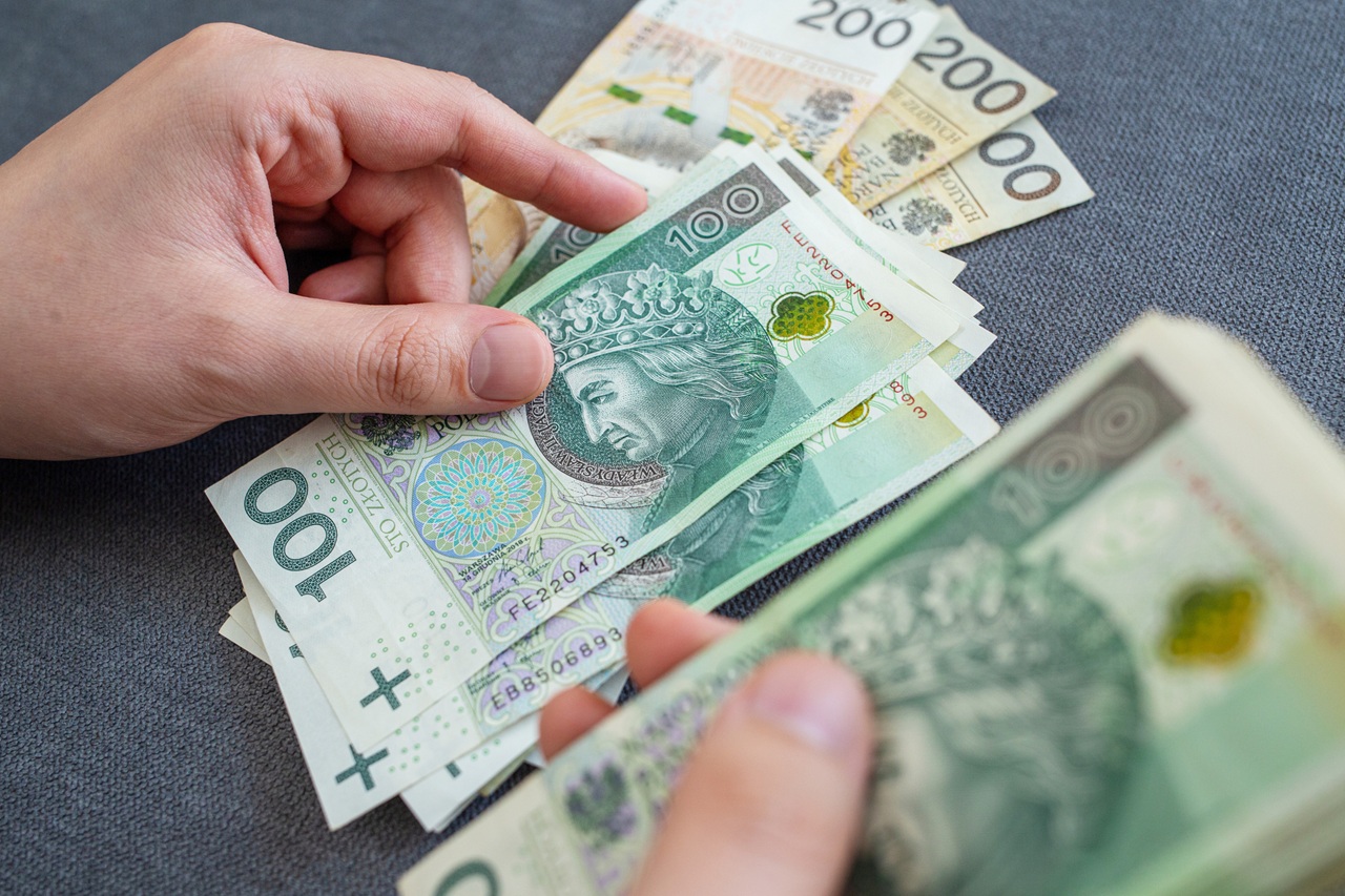 Mężczyzna liczy pieniądze wypłacone z lokaty